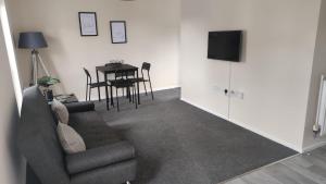 a living room with a couch and a table at Lovely 1 bedroom studio apartment - Merthyr Tydfil in Merthyr Tydfil