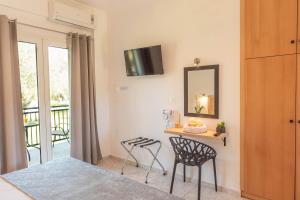 Yianetta Hotel Apartments في كافوس: غرفة مع طاولة وكرسيين ومرآة