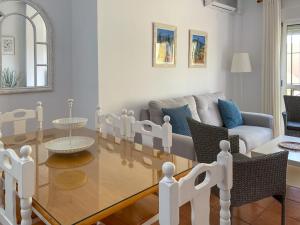 a living room with a glass table and a couch at Disfrute de las playas y el golf en nuestro adosado en Islantilla - Costa de la Luz in Lepe