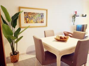 a dining room table with chairs and a plant at 3B flat in Portimão