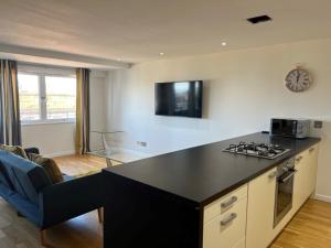 eine Küche mit einer schwarzen Arbeitsplatte in einem Zimmer in der Unterkunft Modern & Spacious 2 bed Merchant City Apart-High St in Glasgow
