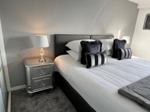 a bedroom with a bed with black and white pillows at Modern & Spacious 2 bed Merchant City Apart-High St in Glasgow