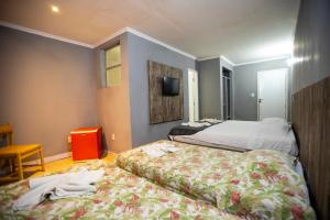 a hotel room with two beds and a tv at HANNA Arcos d'Atalaia Hotel - Aracaju in Aracaju