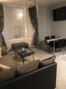 een woonkamer met een bank en een tafel bij Baxter Holiday Apartments in Blackpool