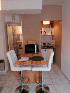 a kitchen with a table and chairs and a microwave at Le Valhalla, studio au pied des thermes in Rennes-les-Bains
