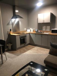 een keuken met een fornuis en een aanrechtblad bij Baxter Holiday Apartments in Blackpool +28 foto's