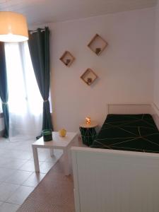 a bedroom with a bed and a table and a window at Le Valhalla, studio au pied des thermes in Rennes-les-Bains