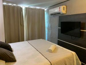 a bedroom with a bed and a flat screen tv at HANNA Arcos d'Atalaia Hotel - Aracaju in Aracaju