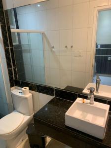 a bathroom with a white toilet and a sink at Beira do Mar Aracaju in Aracaju