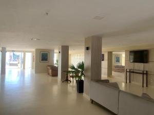 a large living room with a couch and a tv at HANNA Arcos d'Atalaia Hotel - Aracaju in Aracaju