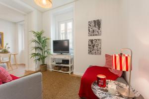 - un salon avec un canapé et une télévision dans l'établissement Charming Apartment for a Great Stay in Lisbon, à Lisbonne
