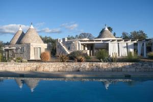 una casa con una piscina di fronte di Regina di Ulivi a Ostuni