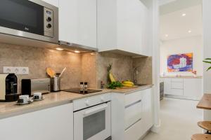 cocina con armarios blancos y microondas en Charming Apartment for a Great Stay in Lisbon, en Lisboa