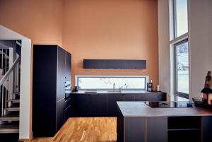 a kitchen with black cabinets and a large window at Lofoten panorama luxury home with sauna in Reine in Reine