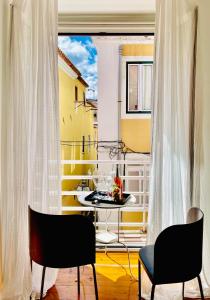 Habitación con balcón con mesa y sillas. en PAZ 38 - Premium Location en Lisboa