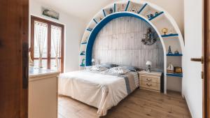 ein Schlafzimmer mit einem Bogen und einem Bett darin in der Unterkunft Villa Boat - in front of the Sea in Stintino