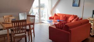ein Wohnzimmer mit einem roten Sofa und einem Tisch in der Unterkunft Apartment Lüdicke in Kirchdorf