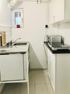 a white kitchen with a sink and a microwave at Bambus Wohnung in Murrhardt