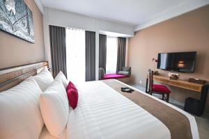 a hotel room with a large bed and a television at Royal Regantris Trawangan in Gili Trawangan