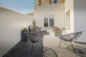 Un balcón con sillas y mesas en un edificio en Casa dos 4 Caminhos - Guest House Douro en Peso da Régua