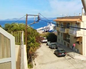 Aussicht vom Balkon eines Gebäudes mit geparkten Autos in der Unterkunft CozyCoast in Rafina