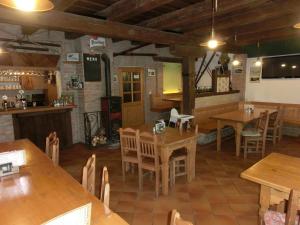 an empty restaurant with wooden tables and chairs at Penzion Kaminek in Rokytnice nad Jizerou