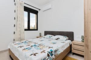 a bedroom with a large bed and a window at Ell Star Apartment in Tivat