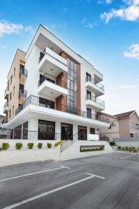 an apartment building with a parking lot in front of it at Ell Star Apartment in Tivat