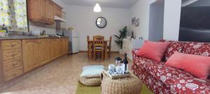 ein Wohnzimmer mit einem roten Sofa und einer Küche in der Unterkunft Casa Nela. Rural y acogedora en Las Puntas El Hierro in Frontera