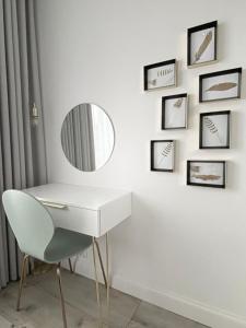 a white dressing table with a mirror and a chair at Apartament Złote Noce in Augustów