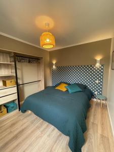 - une chambre avec un lit et une couette bleue dans l'établissement la casa verde 2 chambres 2 salles de bain 2 wc jardin, à Compiègne