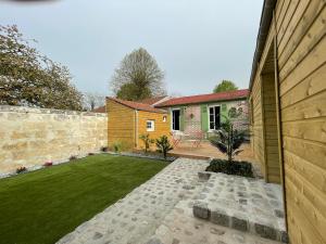 un jardín con una pared de retención y un patio trasero en la casa verde 2 chambres 2 salles de bain 2 wc jardin en Compiègne