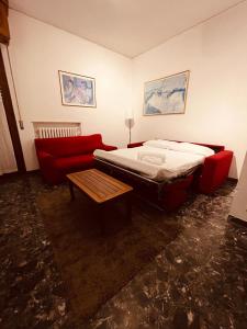 una camera con un letto e un divano rosso di Appartamento lazise a Lazise
