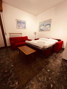 sypialnia z łóżkiem i czerwoną kanapą w obiekcie Appartamento lazise w mieście Lazise