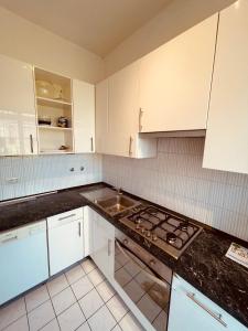 kuchnia z białymi szafkami i piekarnikiem w obiekcie Appartamento lazise w mieście Lazise