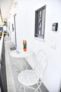un patio con 2 tavoli, sedie e una finestra di Casa Carolina a Ischia