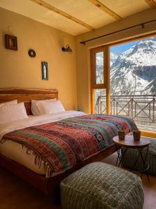 a bedroom with a bed with a view of a mountain at La Hault in Sissu