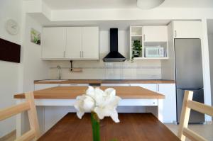 a kitchen with white cabinets and a table with a white flower at Agaete Paraíso in Agaete