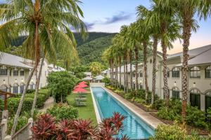 棕榈湾Calypso at Mango Lagoon Resort的享有度假村外的游泳池和棕榈树景致