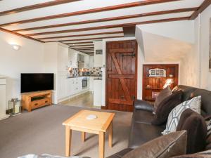 a living room with a couch and a table at Burford Cottage in Weston on Avon