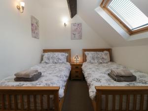 two twin beds in a room with a window at Burford Cottage in Weston on Avon