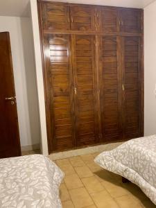 a bedroom with a wooden closet and a bed at Los Naranjos Departamentos 1 in Concepción