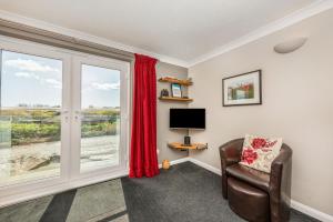 a living room with a window and a chair and a television at 16 The Boathouse in Rye