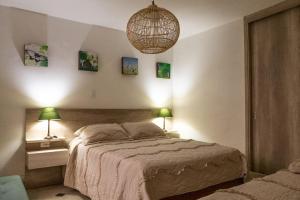 a bedroom with a bed with two lamps and a chandelier at Hotel Casa Esencia in Medellín