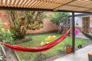 a hammock in a garden with potted plants at Hotel Casa Esencia in Medellín
