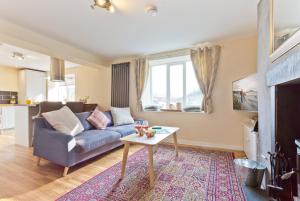 a living room with a blue couch and a table at Harley House in Broughton in Furness
