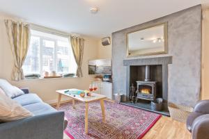 a living room with a couch and a fireplace at Harley House in Broughton in Furness