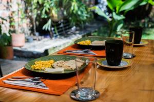 a wooden table with plates of food and wine glasses at Hotel Casa Esencia in Medellín +36 photos