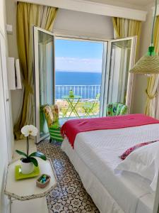 a bedroom with a bed and a view of the ocean at Casa Marta Capri in Capri