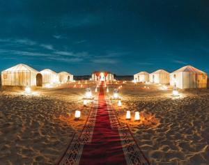 a long red carpet on the beach at night at Camp Sahara berber in Merzouga